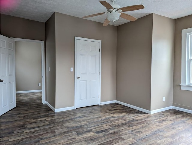 unfurnished bedroom with dark hardwood / wood-style flooring, a textured ceiling, and ceiling fan