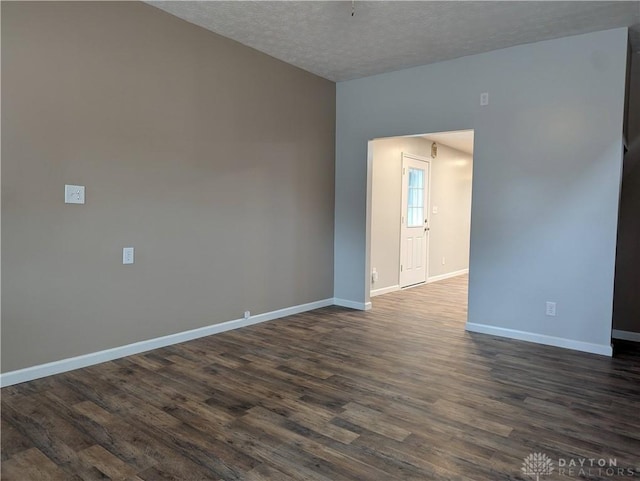 empty room with a textured ceiling and dark wood-type flooring