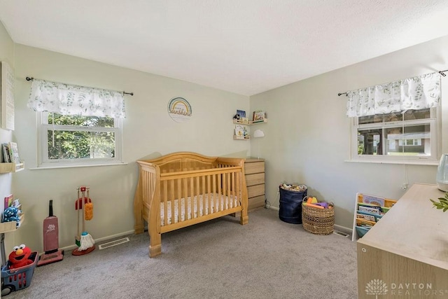 bedroom featuring carpet flooring and a nursery area