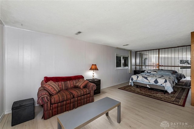 bedroom featuring light hardwood / wood-style flooring and a textured ceiling