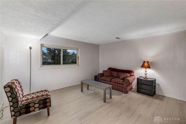 living room with light hardwood / wood-style flooring and a textured ceiling