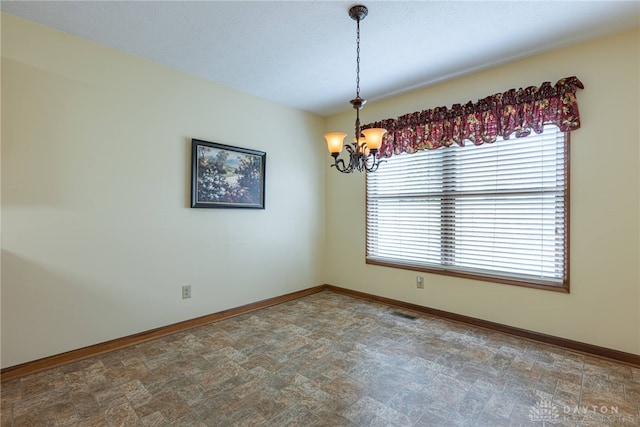 spare room featuring a chandelier