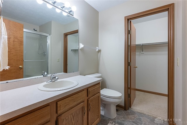 bathroom with vanity, toilet, and a shower with shower door