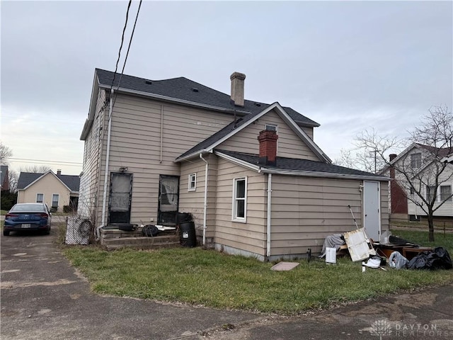 rear view of property with a lawn