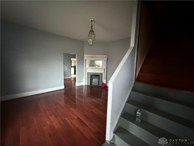 stairway with hardwood / wood-style flooring and an inviting chandelier