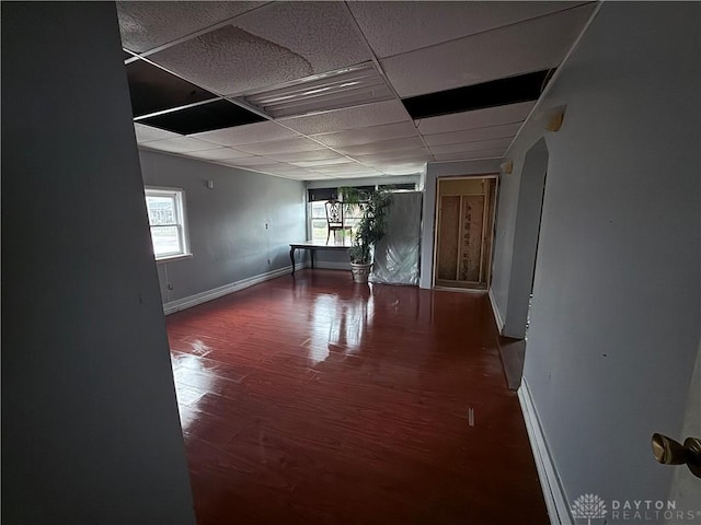 unfurnished room featuring a drop ceiling and dark wood-type flooring