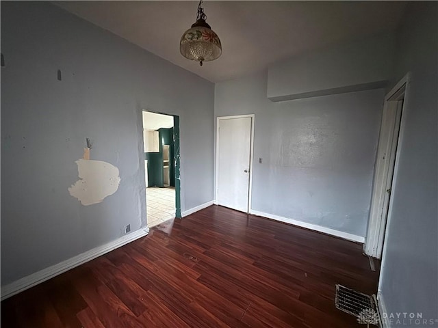 unfurnished room with dark hardwood / wood-style flooring