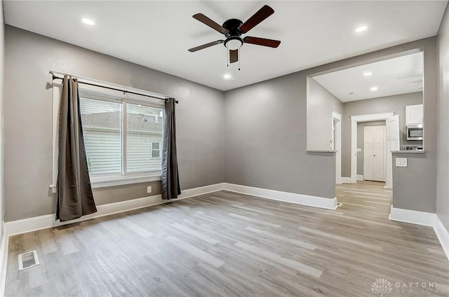 empty room featuring ceiling fan and light hardwood / wood-style flooring