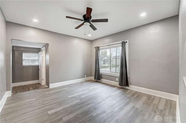 empty room with ceiling fan and light hardwood / wood-style floors