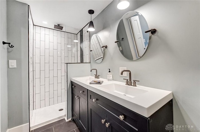 bathroom featuring tile patterned flooring, vanity, and tiled shower