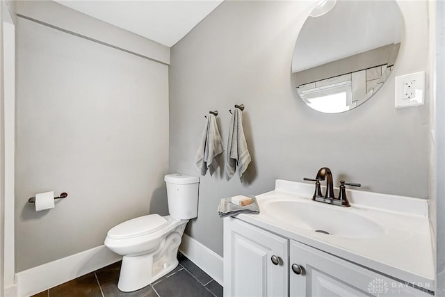 bathroom with toilet, vanity, and tile patterned floors