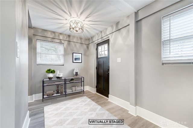 entryway featuring light hardwood / wood-style floors and a chandelier