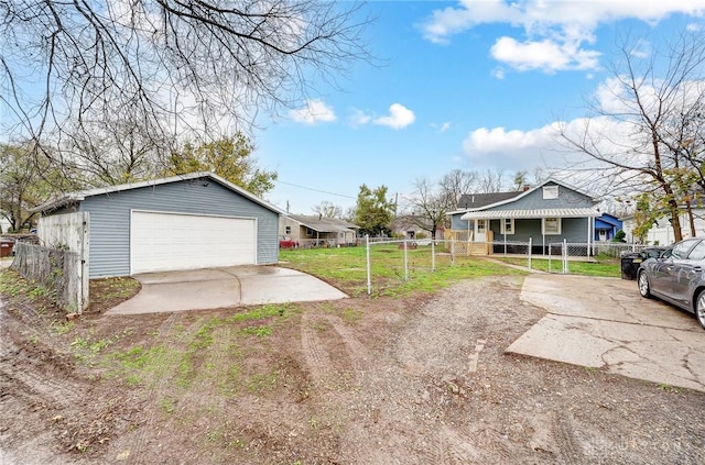 view of yard with covered porch, a garage, and an outbuilding