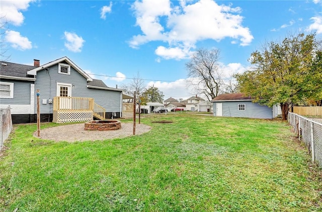 view of yard featuring an outdoor fire pit and a wooden deck