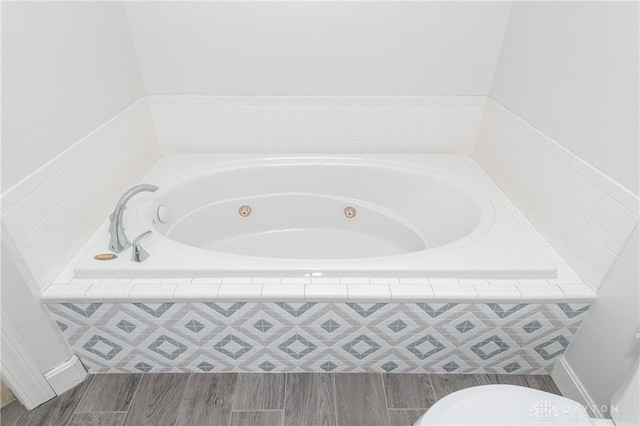 full bathroom featuring a jetted tub and wood finished floors