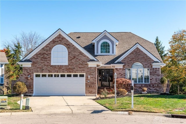 traditional-style house with brick siding, driveway, a shingled roof, and a front yard