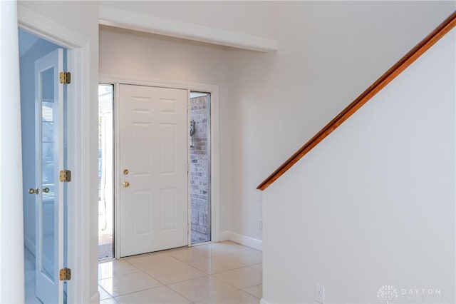 entrance foyer with light tile patterned flooring and baseboards