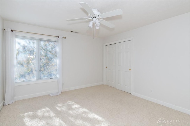 unfurnished bedroom with carpet flooring, baseboards, visible vents, and a closet