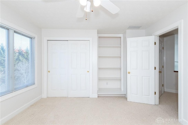 unfurnished bedroom with light colored carpet, a closet, and baseboards