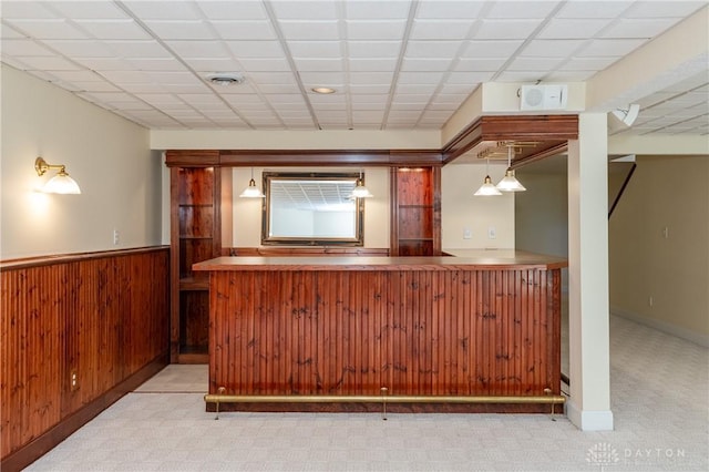 bar featuring visible vents, a wainscoted wall, wood walls, a dry bar, and carpet flooring