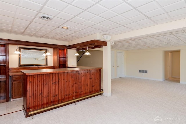 bar with a bar, light colored carpet, visible vents, and baseboards