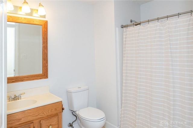 bathroom featuring vanity, curtained shower, and toilet