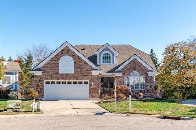 traditional-style house featuring driveway, roof with shingles, a front lawn, a garage, and brick siding