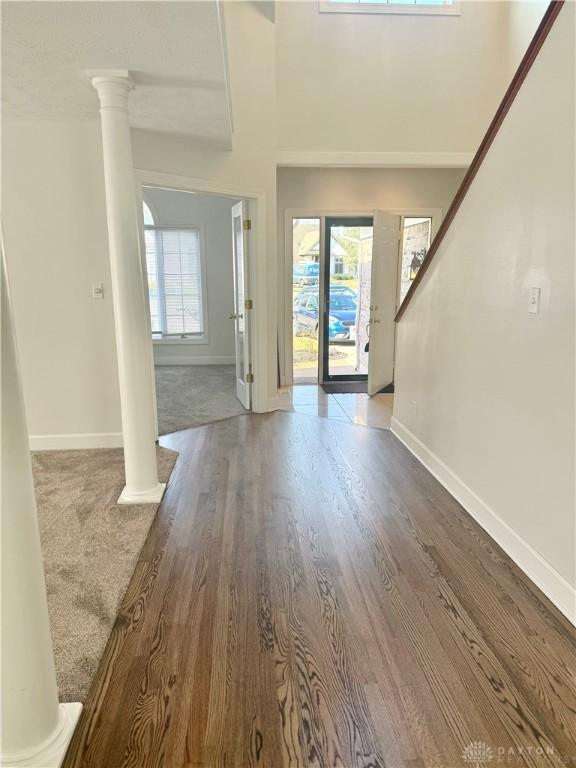 entryway with baseboards and decorative columns