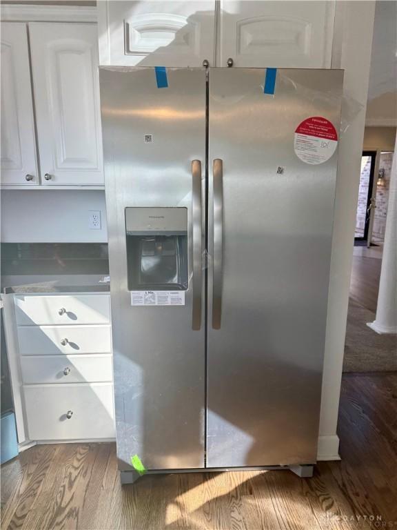 kitchen featuring white cabinets, wood finished floors, and stainless steel fridge with ice dispenser