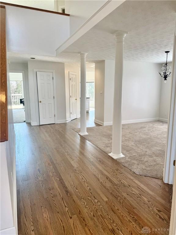 below grade area featuring a chandelier, baseboards, and wood finished floors