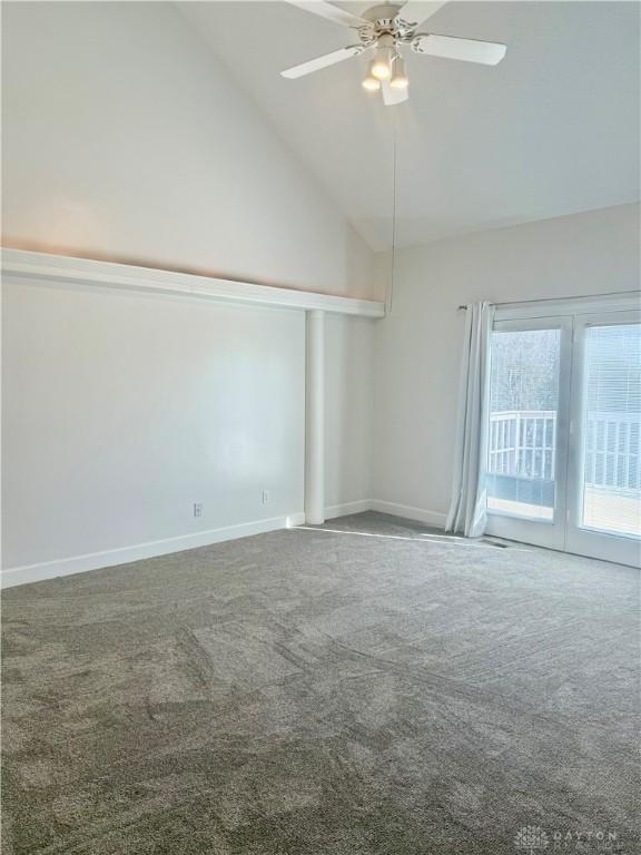 carpeted spare room with high vaulted ceiling, baseboards, and ceiling fan