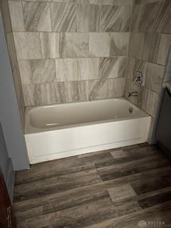 bathroom with hardwood / wood-style floors and shower / bath combination