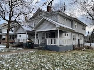 view of front of home with a chimney and covered porch