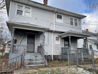 view of front of house with a chimney and covered porch