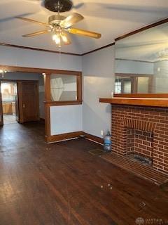 unfurnished living room featuring a fireplace, dark hardwood / wood-style flooring, ceiling fan, and ornamental molding