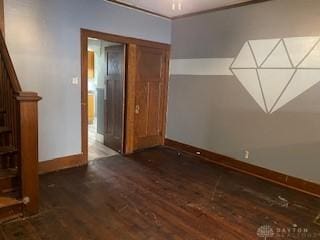 unfurnished room featuring stairway, baseboards, and wood finished floors