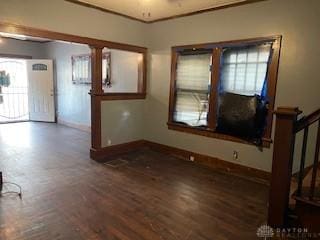 unfurnished room featuring stairs, baseboards, and wood finished floors