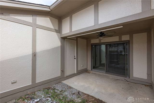 entrance to property featuring ceiling fan and a patio