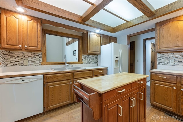 kitchen with light wood-type flooring, white appliances, sink, and tasteful backsplash