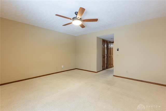 unfurnished room featuring a textured ceiling, light colored carpet, and ceiling fan