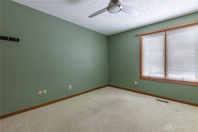 spare room with ceiling fan, carpet floors, and a textured ceiling