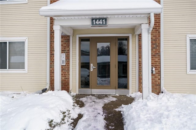 snow covered property entrance with french doors