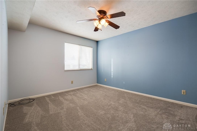 carpeted spare room with a textured ceiling and ceiling fan