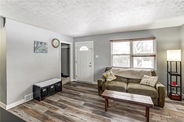 living room with dark hardwood / wood-style floors and a textured ceiling