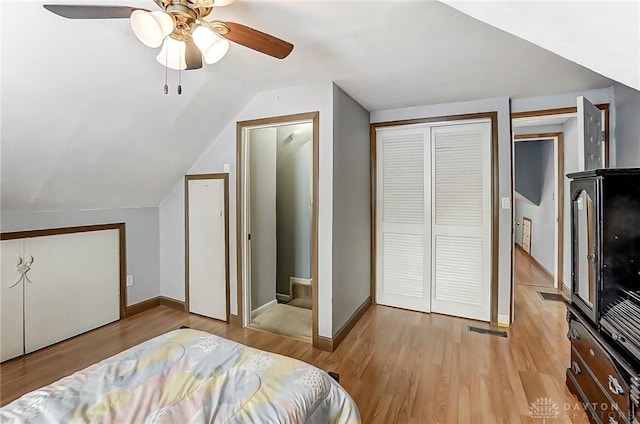 bedroom with connected bathroom, light hardwood / wood-style floors, ceiling fan, and lofted ceiling