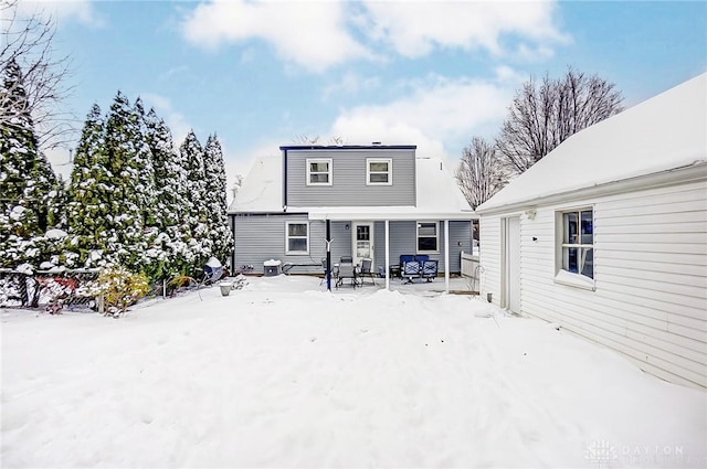 view of snow covered back of property