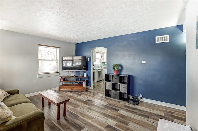 living room with wood-type flooring and a textured ceiling