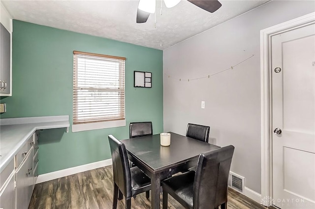 dining area with ceiling fan, dark hardwood / wood-style flooring, and a textured ceiling