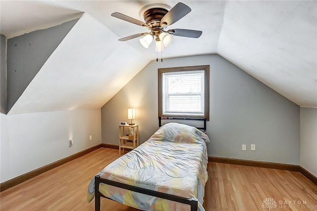 bedroom featuring ceiling fan, light hardwood / wood-style floors, and vaulted ceiling