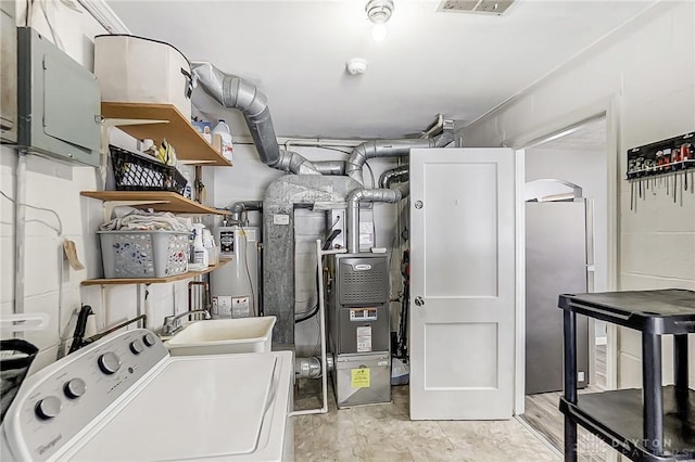 utility room with heating unit, washer / clothes dryer, sink, water heater, and electric panel